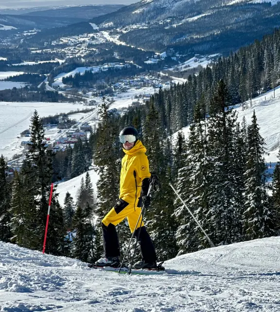 Robin Hallabro-Kokko skiing in a yellow jacket on a mountain slope