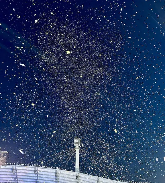 Confetti falling over a stadium at night